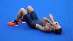 Atlet Bermuda, Flora Duffy berbelebrasi setelah melewati garis finis untuk meraih medali emas dalam triathlon nomor individu putri Olimpiade Tokyo 2020 di Odaiba Marine Park, Selasa (27/7/2021). Flora Duffy menjadi penyumbang medali emas untuk negara berpenduduk 60 ribu orang itu. (AP/David Goldman)