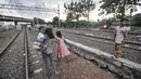 Anak-anak saat bermain di dekat rel kereta api di kawasan Bahari Ujung, Tanjung Priok, Jakarta Utara, Selasa (24/5/2022). Minimnya fasilitas dan ruang terbuka hijau di kawasan tersebut menyebabkan anak-anak setempat memilih bermain di sekitar perlintasan kereta api yang dapat membahayakan keselamatan mereka. (merdeka.com/Iqbal S Nugroho)