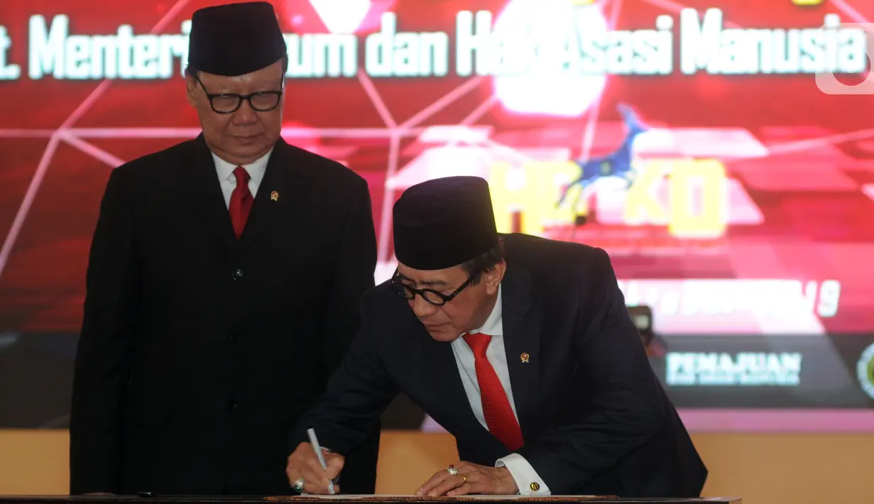 Yasonna Laoly (kanan) disaksikan Tjahjo Kumolo menandatangani berkas saat serah terima jabatan Menteri Hukum dan Hak Asasi Manusia (Menkumham) di Jakarta, Rabu (23/10/2019). Yasonna Laoly menggantikan Tjahjo Kumolo yang sebelumnya menjabat Plt Menkumham. (merdeka.com/Dwi Narwoko)