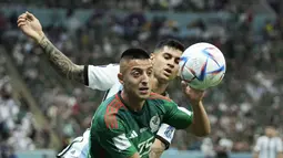 Penyerang Meksiko, Roberto Alvarado berebut bola dengan bek Argentina, Cristian Romero selama pertandingan grup C Piala Dunia 2022 Qatar di Stadion Lusail di Lusail, Qatar, Minggu 27 November 2022. Argentina  kini berada diuturan kedua klasemen dengan dua poin. (AP Photo/Hassan Ammar)