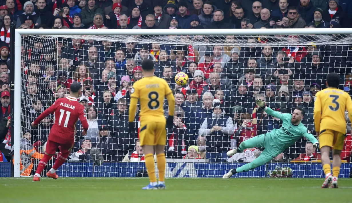 Pemain Liverpool, Mohamed Salah mencetak gol melalui tendangan penalti ke gawang Wolverhampton dalam laga lanjutan Liga Inggris 2024/2025 di Anfield, Liverpool, Inggris, Minggu (16/02/2025). (AP Photo/Ian Hodgson)