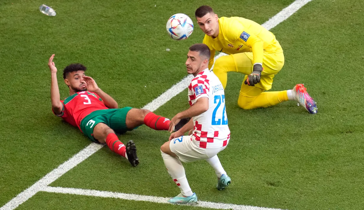 Pemain Maroko Noussair Mazraoui (kiri) berebut bola dengan pemain Kroasia Josip Juranovic dan kiper Dominik Livakovic pada pertandingan sepak bola Grup F Piala Dunia 2022 di Stadion Al Bayt, Al Khor, Qatar, Rabu (23/11/2022). Pertandingan berakhir imbang dengan skor 0-0. (AP Photo/Darko Vojinovic)