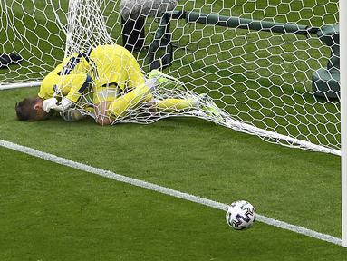 Kiper Skotlandia David Marshall tersangkut pada jaring gawang setelah gagal menyelamatkan tendangan jarak jauh pemain Republik Ceko Patrik Schick pada pertandingan Grup D Euro 2020 di Stadion Hampden Park, Glasgow, Inggris, Senin (14/6/2021). (AP Photo/Andy Buchanan, Pool)