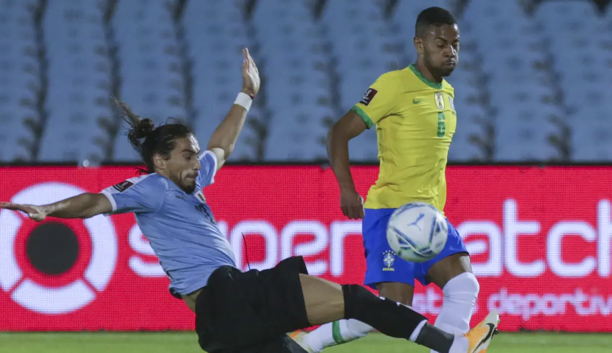 Bek Brasil, Renan Lodi, berebut bola dengan bek Uruguay, Martin Caceres, pada laga lanjutan kualifikasi Piala Dunia zona CONMEBOL di Estadio Centenario, Rabu (18/11/2020) pagi WIB. Brasil menang 2-0 atas Uruguay. (AFP/Matilde Campodonico/pool)