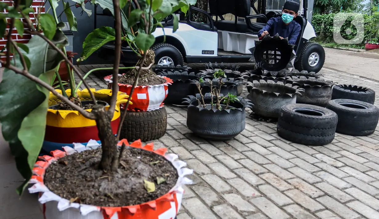 Abdul Kholik menyelesaikan pembuatan pot bunga dari ban bekas di Galeri Abdul Kholik, Tapos, Depok, Jumat (30/10/2020). Kerajinan pot bunga dari limbah ban bekas mobil Boogie Car atau mobil golf itu dijual seharga Rp75 ribu hingga Rp100 ribu tergantung warna dan ukuran. (Liputan6.com/Johan Tallo)