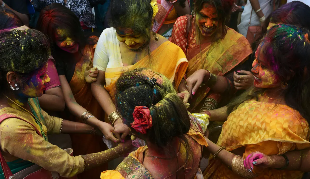 Sejumlah siswi menaburkan bubuk warna selama mengikuti perayaan Holi di Kolkata, India (7/3). Festival ini dikenal dengan acaranya yang khas yaitu saling menaburkan semacam bubuk yang berwarna-warni. (AFP/Dibyangshu)