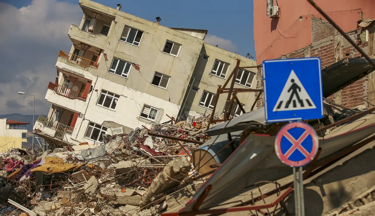 Sebuah bangunan hancur bersandar di rumah menyusul gempa di Samandag, Turki selatan, Rabu, 22 Februari 2023. Korban selamat dari gempa yang mengguncang Turki dan Suriah 15 hari lalu, menewaskan puluhan ribu orang dan menyebabkan ratusan ribu lainnya kehilangan tempat tinggal , menghadapi lebih banyak trauma dan kehilangan setelah gempa mematikan dan gempa susulan mengguncang wilayah tersebut. (AP Photo/Emrah Gurel)