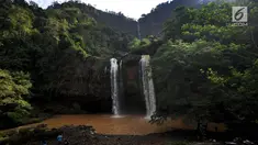 Wisatawan mengambil gambar curug Sodong Kembar di kawasan Ciletuh Geopark, Sukabumi, Sabtu (23/6). Tempat ini kian populer karena keindahan alamnya dan batuan alamnya yang dihadirkan di setiap obyek wisata di Geopark Ciletuh. (Merdeka.com/Arie Basuki)