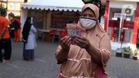 Warga menunjukkan uang usai melakukan penarikan bantuan sosial tunai (BST) di ATM Bank DKI di Jakarta, Selasa (20/7/2021). Pemprov DKI Jakarta resmi mencairkan BST kepada warga DKI Jakarta. (Liputan6.com/Angga Yuniar)