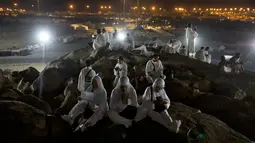 Jemaah calon haji berdoa saat berada di Bukit Jabal Rahmah, saat mereka tiba di Arafah untuk menjalani wukuf di luar kota suci Mekah, Arab Saudi (30/8).  (AP Photo / Khalil Hamra)