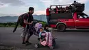 Seorang imigran Honduras mendorong kereta bayi dengan dua anaknya dalam perjalanannya menuju AS di Oaxaca, Meksiko, 29 Oktober 2018. Kereta dorong bayi tak hanya untuk balita mereka, tetapi juga dapat digunakan membawa barang-barang. (Guillermo Arias/AFP)