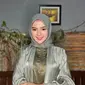 Ia menyempurnakan penampilannya dengan hijab warna hijau sage. Wajahnya pun dipoles dengan makeup natural.