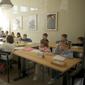 Guru Ukraina Tatyana Gubskaya (tengah) mengajar kelas anak-anak dari Ukraina di Berlin, Jerman, Senin (21/3/2022). Empat puluh anak pengungsi Ukraina memulai hari pertama sekolah dasar di Berlin hanya beberapa minggu setelah mereka melarikan diri dari perang. (AP Photo/Markus Schreiber)