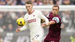 Gelandang Manchester United, Scott McTominay (kiri) menguasai bola di depan gelandang West Ham United, Tomas Soucek pada laga pekan ke-18 Liga Inggris 2023/2024 di London Stadium, London, Sabtu (23/12/2023). (AP Photo/Kirsty Wigglesworth)