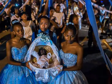 Afro-Kolombia memegang keranjang yang berisi "Nino Dios" (God Child) selama perayaan "Adoraciones al Nino Dios" di Quinamayo, Kolombia (18/2). Acara tersebut adalah perayaan Natal tradisional komunitas Afro-Kolombia. (AFP Photo/Luis Robayo)