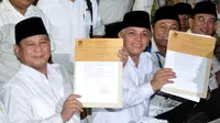 Capres dari partai Gerindra, Prabowo Subianto dan cawapres dari partai PAN Hatta Rajasa melihatkan berkas yang sudah ditanda tangani petugas KPU. Selasa (20/5/14) (Liputan6.com/Johan Tallo)