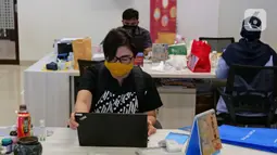 Karyawan membuka laptop sebelum memulai aktivitas bekerja di Suntory Garuda, Jakarta, Senin (8/8/2020). Perusahaan tersebut menerapkan protokol kesehatan saat hari pertama kerja di masa PSBB transisi yang diterapkan oleh Pemprov DKI Jakarta. (Liputan6.com/Herman Zakharia)