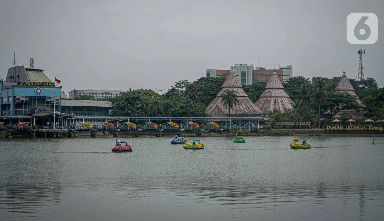 Pengunjung menaiki perahu angsa di kawasan Taman Mini Indonesia Indah, Jakarta, Minggu (12/10/2021). Uji coba pengoperasian tempat wisat ini harus  dengan Kapasitas pengunjung pada masa uji coba dibatasi hanya 25 persen. (Liputan6.com/Faizal Fanani)