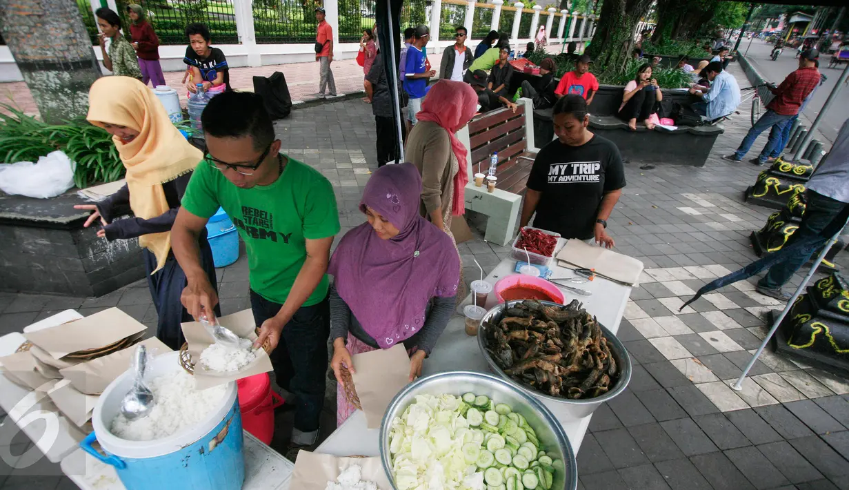 Para pekerja sibuk melayani pelanggan di warung tenda Shodaqoh di kawasan titik nol Km Yogyakarta, Jumat (8/4). Warung yang hanya buka setiap hari Jumat pada pukul 11.00-13.00 WIB ini digratiskan untuk kaum fakir miskin dan dhuafa. (Foto: Boy Harjanto)