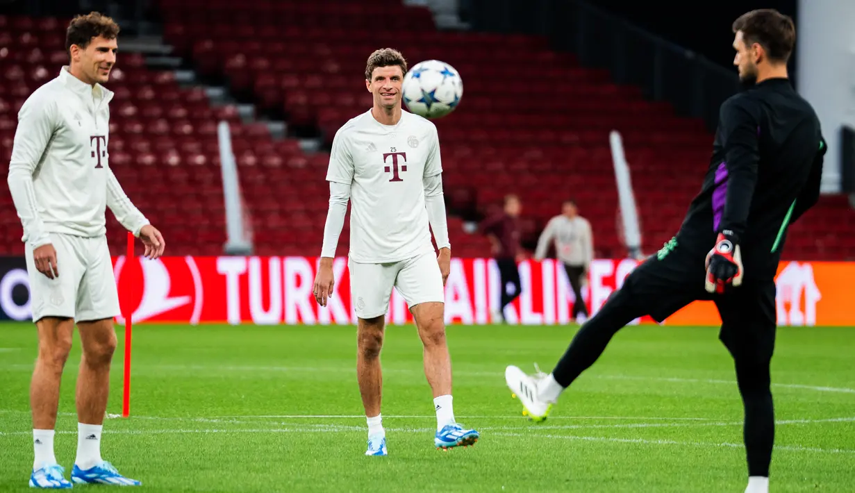 Penyerang Bayern Munchen #25 Thomas Mueller (tengah) dan gelandang Bayern Munchen #08 Leon Goretzka (kiri) bermain bola saat mereka menghadiri sesi latihan pada malam matchday 2 Grup A Liga Champions 2023/2024 di Stadion Parken, Kopenhagen, Senin (2/10/2023). (Martin Sylvest / Ritzau Scanpix / AFP)