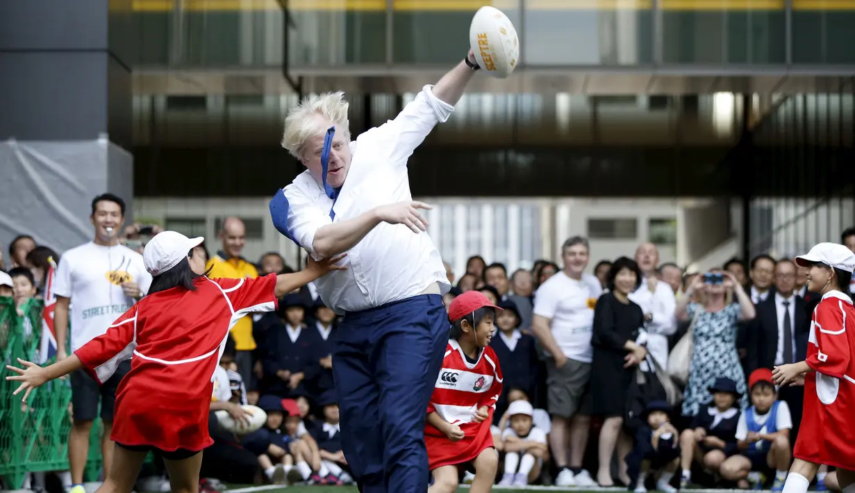 Walikota London Boris Johnson (kanan) asik bermain dengan anak - anak sekolah dasar di sebuah lapangan mini, Tokyo, Jepang, Kamis (15/10/2015).  Boris bermain Rugby untuk menyambut Jepang sebagai tuan rumah Piala Dunia Rugby 2019. (REUTERS/Issei Kato) 