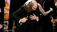Produser La La Land, Jordan Horowitz (kiri) berpelukan dengan sutradara Moonlight, Barry Jenkins usai kesalahan pembacaan pemenang film terbaik di ajang Oscar 2017 di Hollywood, California, AS (26/2). (AFP/Getty Images/Kevin Winter)