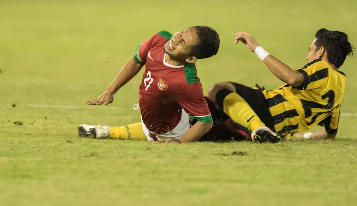Gelandang Indonesia, Andik Vermansah, dijatuhkan bek sayap Malaysia, Mohd Azrif Nasrulhaq. Pada laga itu wasit mengeluarkan dua kartu kuning untuk pemain Malaysia. (Bola.com/Vitalis Yogi Trisna)