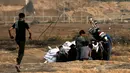 Suasana saat pemuda Palestina, Mohammad Safy membagikan jus kepada pengunjuk rasa di perbatasan Israel dengan Gaza, Jumat (13/4). (MAHMUD HAMS/AFP)