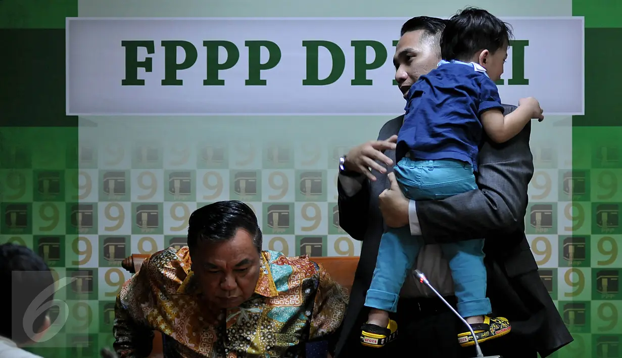 Anggota DPR Fraksi PPP, Ivan Haz (kanan) menggendong anaknya seusai memberikan keterangan pers di Kompleks Parlemen, Senayan, Jakarta, Jumat (9/10). Ivan membantah menganiaya PRTnya, Topiah. (Liputan6.com/Johan Tallo)