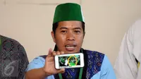 Ketua Umum PB HMI, Mulyadi P Tamsir menunjukkan foto bentrok massa dengan polisi saat aksi damai 4 November, Jakarta, Sabtu (5/11). HMI, PII, dan GPII memberikan pernyataan sikap terkait insiden tersebut. (Liputan6.com/Helmi Fithriansyah)