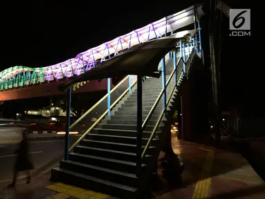 Lampu yang bisa berganti-ganti warna menghiasi jembatan penyeberangan orang (JPO) di kawasan Jakarta Timur, Kamis (27/12). Jembatan ini dihiasi warna warni lampu dengan fasilitas lift untuk para disabilitas menyeberang jalan. (Merdeka.com/Imam Buhori)