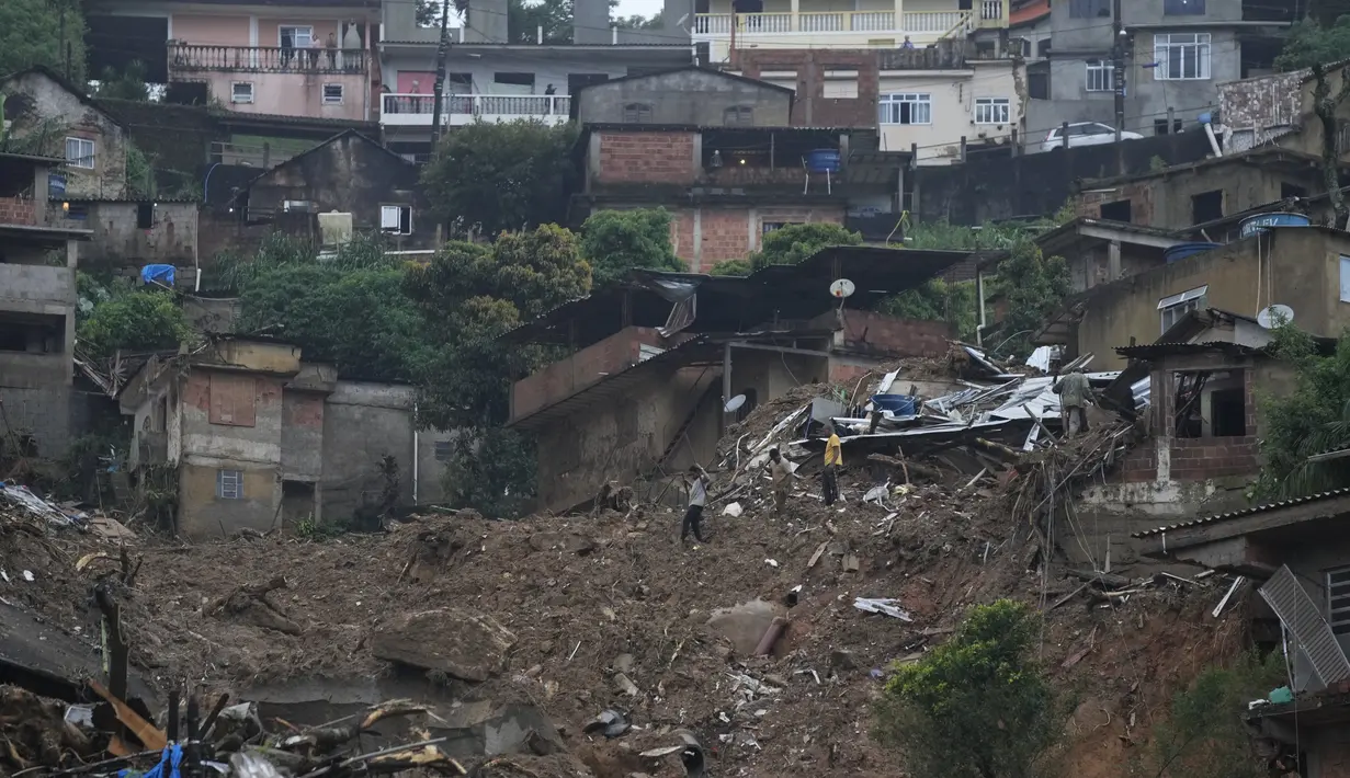 Warga mencari korban di kawasan yang terkena longsor di Petropolis, Brasil, Rabu (16/2/2022). Pihak berwenang melaporkan, Hujan yang sangat deras memicu tanah longsor dan banjir di wilayah pegunungan di negara bagian Rio de Janeiro, menewaskan banyak orang. (AP Photo/Silvia Izquierdo)