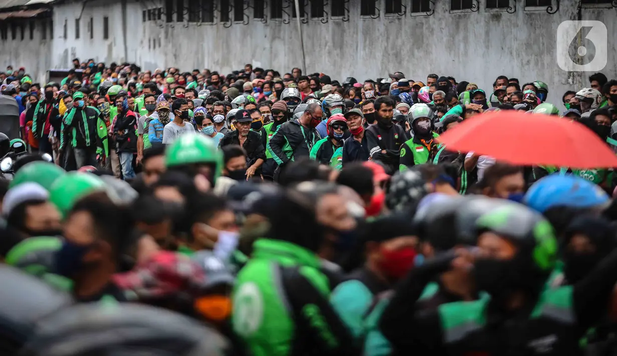 Warga dan pengemudi ojek online mengantre nasi kotak serta masker dari TNI di Markas Komando Gabungan Wilayah I, Jakarta, Selasa (21/4/2020). Dalam rangka Hari Kartini, TNI membagikan makanan dan masker kepada masyarakat. (Liputan6.com/Faizal Fanani)