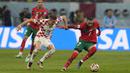 <p>Gelandang Maroko, Hakim Ziyech mengontrol bola dari kawalan pemain Kroasia, Mislav Orsic selama pertandingan playoff perebutan juara ketiga Piala Dunia 2022 di Khalifa International Stadium di Doha, Qatar, Sabtu (17/12/2022). Kroasia meraih juara ketiga Piala Dunia 2022 usai menang 2-1 atas Maroko. (AP Photo/Thanassis Stavrakis)</p>