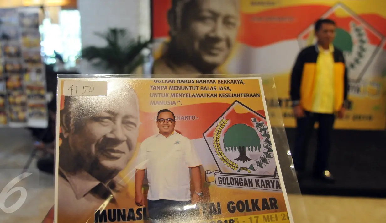 Kader partai menunjukkan hasil fotonya dengan latar belakang gambar Presiden kedua RI, Soeharto disela Musyawarah Nasional Luar Biasa (Munaslub) Partai Golkar di Bali Nusa Dua Convention Center (BNDCC), Bali, Minggu (15/5). (Liputan6.com/Johan Tallo)