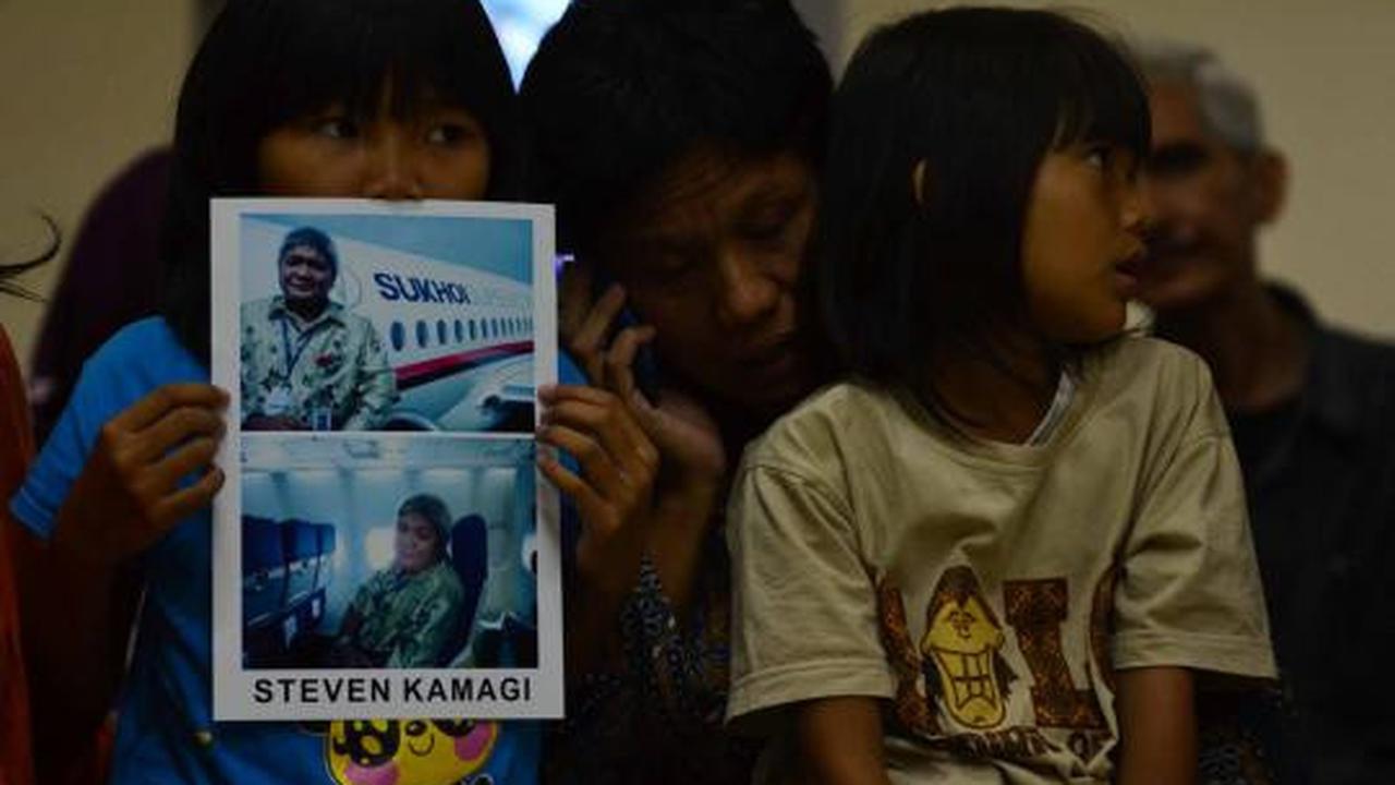 Putri dari Steven Kamagi memegang foto ayahnya yang ikut dalam penerba 
