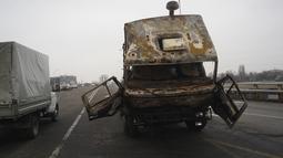 Sebuah truk militer, yang terbakar saat bentrokan, terlihat di sebuah jalan di Almaty, Kazakhstan, Minggu  (9/1/2022). Pihak berwenang telah mendapatkan kembali kendali atas gedung-gedung administrasi. (Vladimir Tretyakov/NUR.KZ via AP)