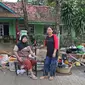 Keluarga ibu Haji Mamah Rusmahwati berpose di depan kediamannya Desa Sumber Urip Pebayuran, Kabupaten Bekasi, Jawa Barat, Senin (22/2/2021). Banjir merenda keluarga tersebut merapikan barang-barang dan bersihkan rumah yang sudah surut. (Liputan6.com/Herman Zakharia)