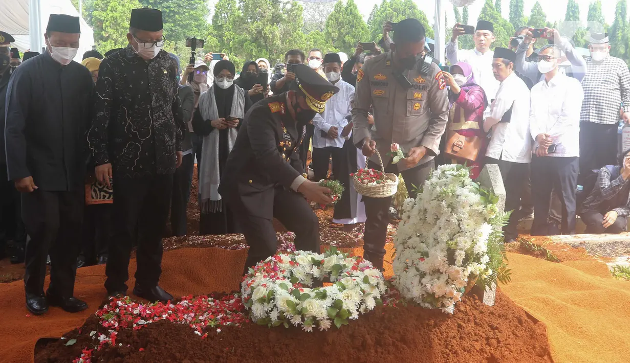 Kapolri Jenderal Listyo Sigit Prabowo menaburkan bunga di atas pusara Almarhum Azyumardi Azra saat prosesi pemakaman di Taman Makam Pahlawan Kalibata, Jakarta, Selasa (20/9/2022). (Liputan6.com/Herman Zakharia)