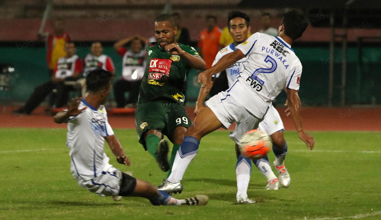 Pemain Bhayangkara Surabaya United, Thiago saat melakukan tembakan melewati hadangan pemain Persib pada lanjutan Torabika Soccer Championship 2016 di Stadion Delta Sidoarjo, Sabtu (11/6/2016). (Bola.com/Nicklas Hanoatubun)