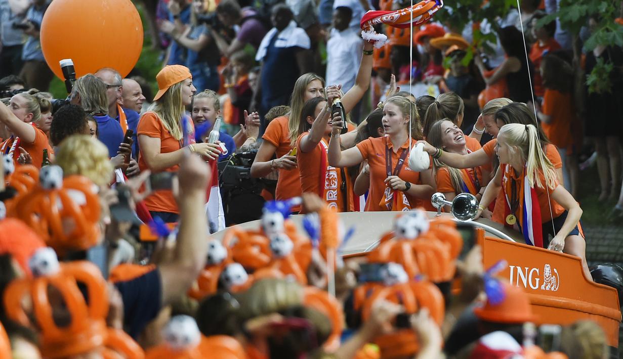 Para pemain timnas putri Belanda menyapa suporter saat merayakan keberhasilan meraih trofi Piala Eropa Wanita 2017 di Sungai Utrecht, (7/8/2017). (AFP/John Thys)