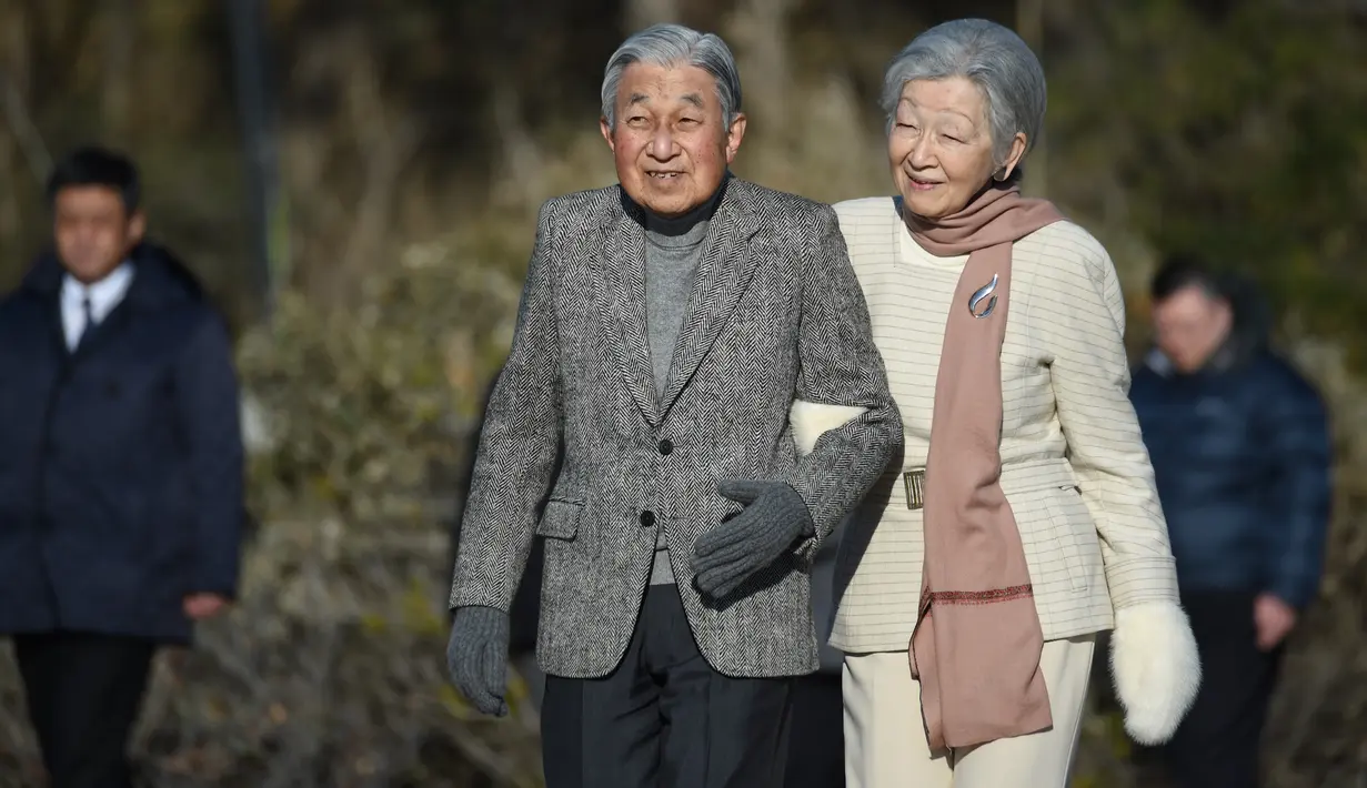 Kaisar Jepang Akihito dan Permaisuri Michiko berjalan-jalan di pantai dekat Hayama Imperial Villa, Prefektur Kanagawa, Senin (21/1). Akihito akan turun takhta pada akhir April 2019 mendatang, mengakhiri pemerintahan selama tiga dekade. (Kazuhiro NOGI/AFP)