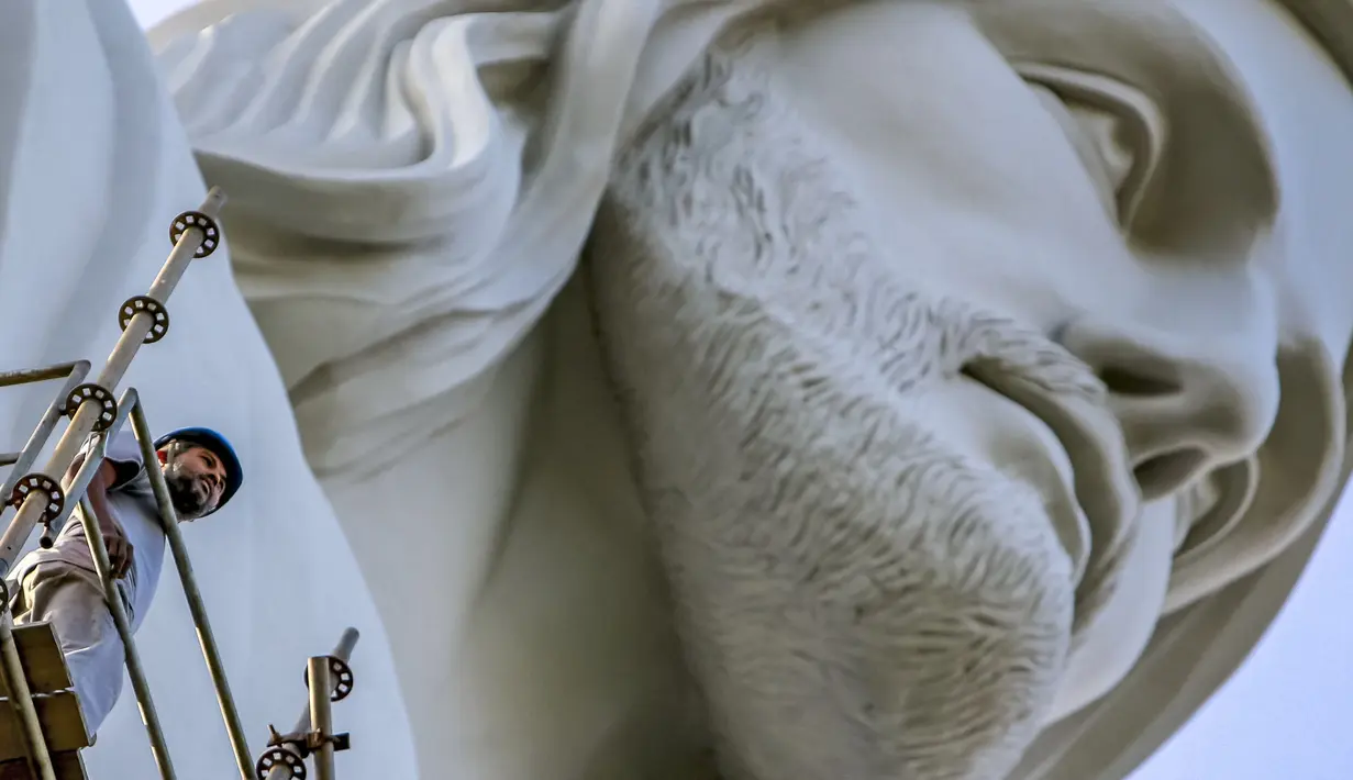 Seorang pekerja terlihat dekat patung Christ the Protector yang sedang dibangun di Encantado, negara bagian Rio Grande do Sul, Brasil, pada 29 Oktober 2021. Patung itu akan lebih besar dari Christ the Redeemer milik Rio de Janeiro dan menjadi tertinggi ketiga di dunia. (SILVIO AVILA / AFP)