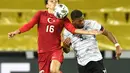 Penyerang Turki, Enes Unal berusaha mengontrol bola dari kawalan bek Jerman, Benjamin Henrichs pada pertandingan persahabatan di Stadion RheinEnergie, Cologne, Kamis  (8/10/2020). Jerman bermain imbang 3-3 atas Turki. (AP Photo/Martin Meissner)