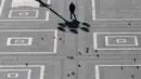 Seorang pria berjalan di Alun-Alun Duomo, Milan, Italia, Minggu (8/3/2020). Italia menutup seluruh wilayahnya dari 10 Maret 2020 sampai 3 April 2020 demi menekan penyebaran virus corona (COVID-19). (AP Photo/Antonio Calanni)