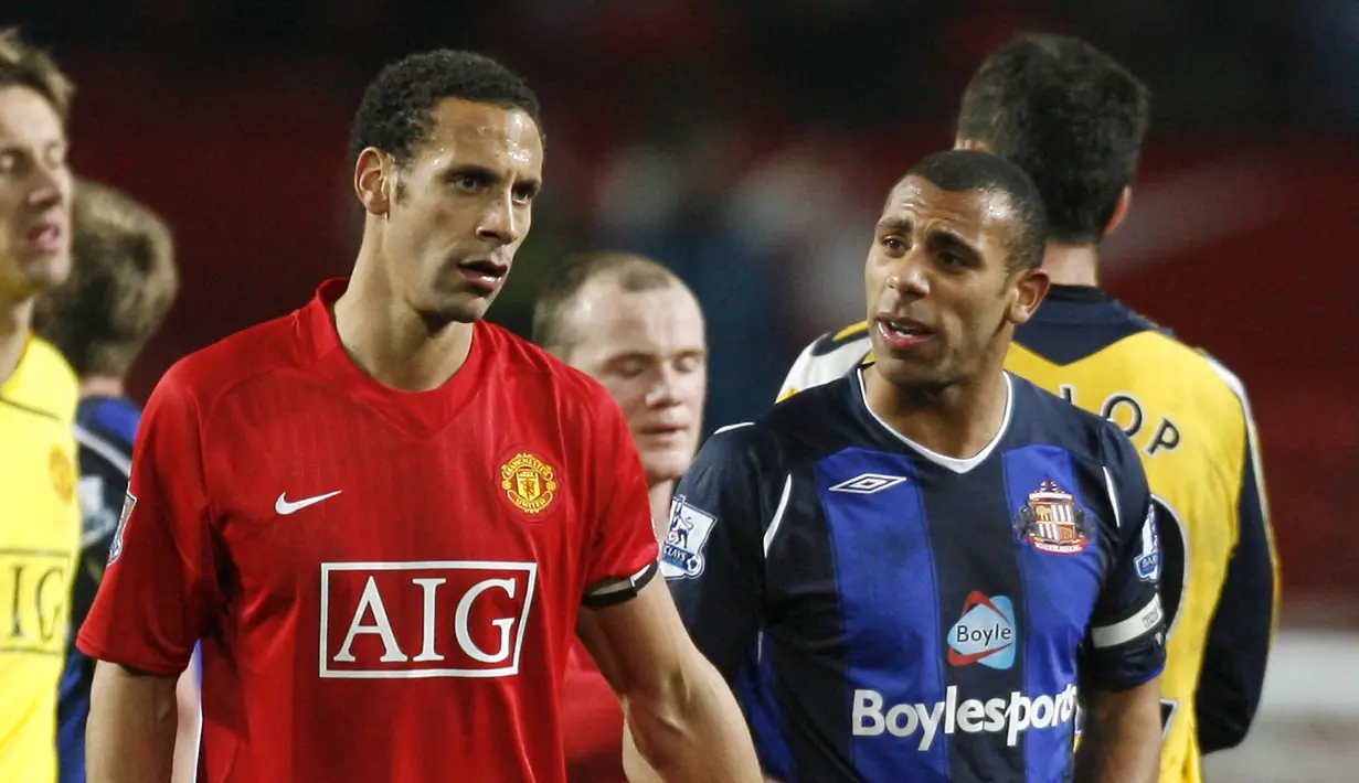 <p>Rio Ferdinand (kiri) merasakan banyak gelar bersama Manchester United, salah satunya gelar Liga Champions. Berbeda dengan karir sang adik, Anton Ferdinand (kanan) yang sempat bermain bagi West Ham musim 2009/2009 dan akhir karirnya bermain untuk St.Mirren di Liga Premier Skotlandia pada musim 2019/2022 sebelum akhirnya memutuskan untuk pensiun pada tahun yang sama. (AFP/Ian Kington)</p>
