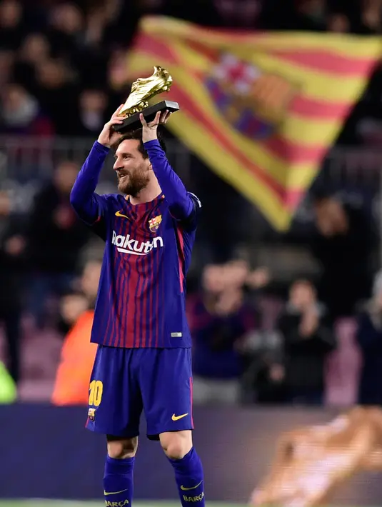 Ekspresi Lionel Messi saat menunjukkan Sepatu Emasnya jelang pertandingan liga Spanyol di stadion Camp Nou di Barcelona (17/12). Messi meraih Sepatu Emas Eropa usai mencetak 37 gol di La Liga musim lalu. (AFP Photo/Javier Soriano)