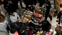 Pembeli berburu tas yang dibanderol harga cukup murah selama perayaan Black Friday di Macy Herald Square, Manhattan, New York, Kamis (24/11). Black Friday menjadi penanda dimulainya musim berbelanja bagi warga AS menjelang Natal. (REUTERS/Andrew Kelly)