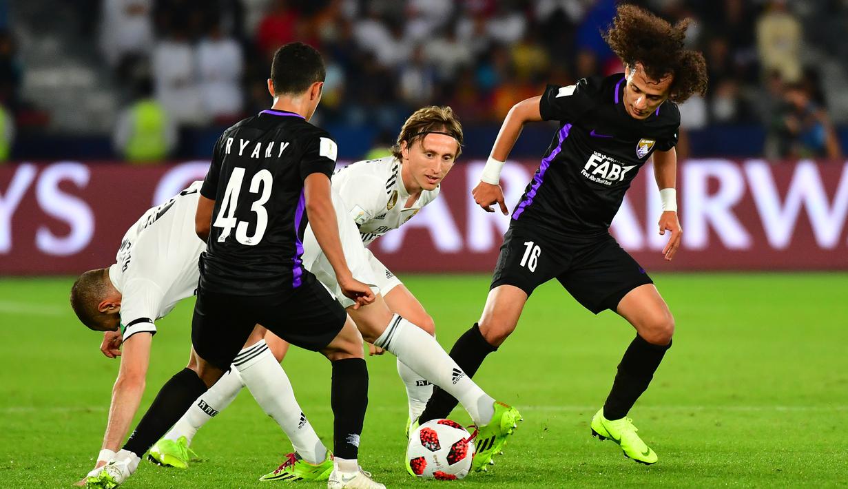 Striker Real Madrid, Karim Benzema, berebut  bola dengan gelandang Al-Ain, Rayan Yaslam, pada laga final Piala Dunia Antarklub di Stadion Zayed Sports City, Abu Dhabi, Sabtu (22/12). Al-Ain kalah 1-4 dari Madrid. (AFP/Giuseppe Cacace)