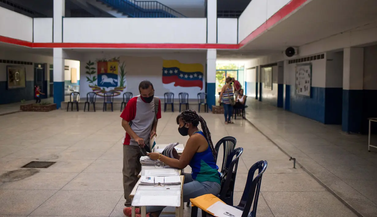Para orang tua mendaftarkan anaknya untuk tahun ajaran baru di aula di SMU "Tito Salas" saat pendaftaran ajaran baru di Las Minas de Baruta, Caracas, 7 Oktober 2020. Di tengah pandemi, kelas dimulai lagi di Venezuela dengan siswa yang harus mencari sinyal internet di jalan. (Cristian Hernandez/AFP)